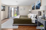 Master bedroom delivers a queen-sized mattress & convenient bedside table lamps -basement floor-